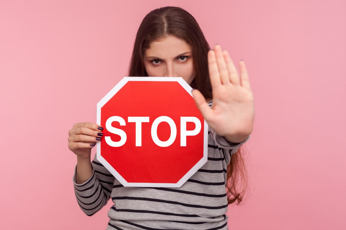 Frau mit Stoppschild und Handfläche